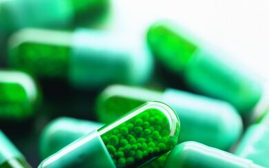 A close-up of green capsule pills