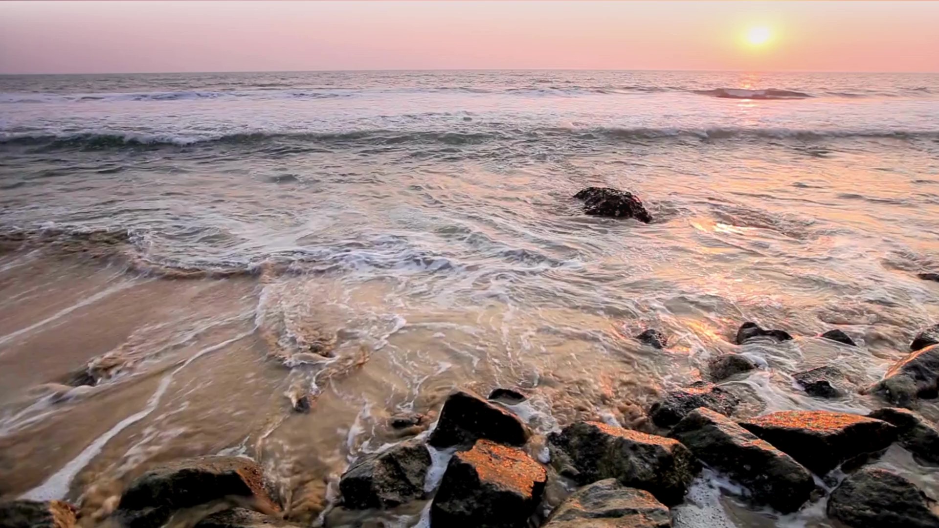 Serene sunset over ocean waves and rocky shoreline, symbolizing global change and the evolving enforcement landscape featured in Hogan Lovells' 2025 Bribery & Corruption Outlook